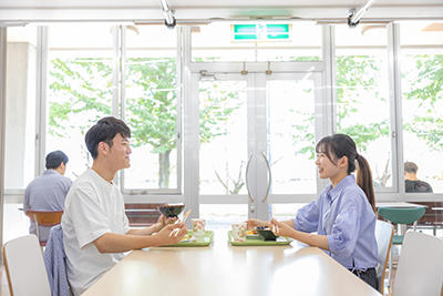 学生がカフェテリアでランチをしている様子